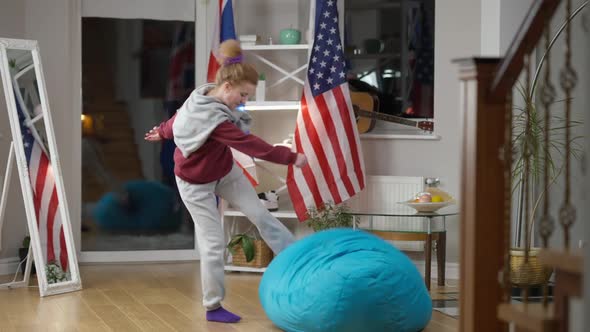 Furious Aggressive Young Woman Kicking Bag Chair in Living Room in the Evening Walking Away Leaving