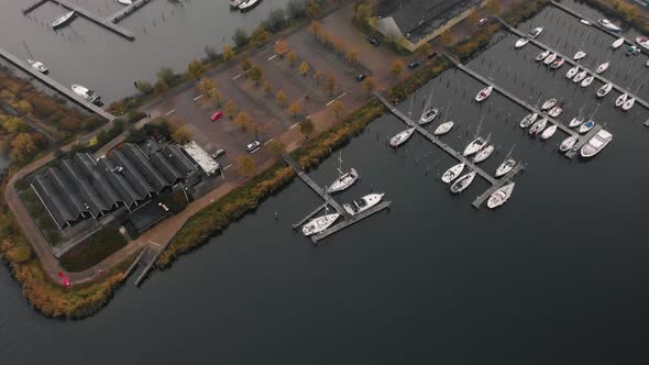 Aerial reveal of a quay with luxury pleasure boats on an overcast dreary cold day in The Netherlands