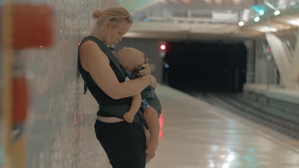 Mum with Sleeping Baby Waiting for Train in Underground