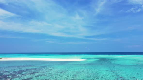 Peaceful seascape with calm clear water of turquoise lagoon, coral reef patterns under water and blu