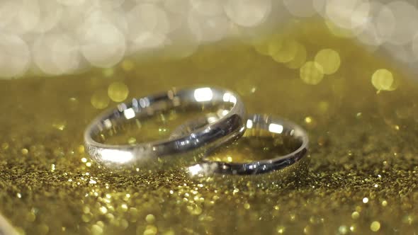 Wedding Silver Rings Lying on Shiny Glossy Surface. Shining with Light. Close-up