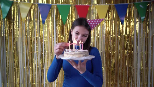 Caucasian Millennial Lights Candles on Birthday Cake at Home Celebrating His Birthday