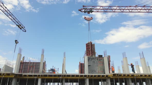 Tower Cranes and Workers at High Concrete Residential Building Under Construction