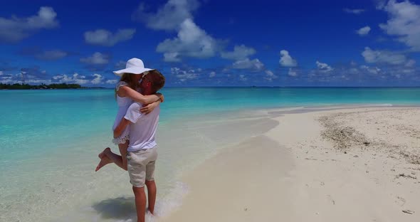 Happy man and woman on romantic honeymoon enjoy luxury on beach on white sand background 