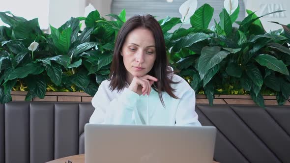 Portrait of a Young Caucasian Female Freelancer Using a Laptop to Work at a Distance Sitting in a