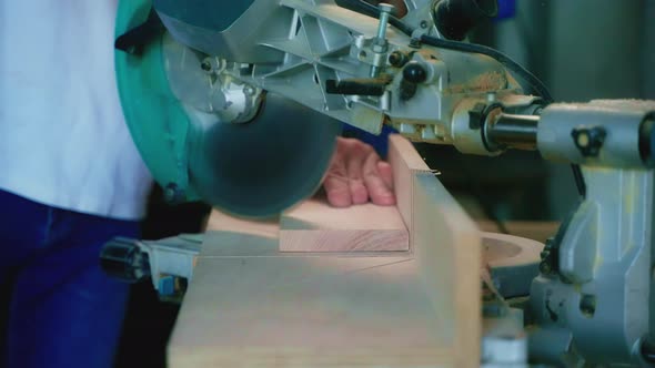 Carpenter is Using Circular Saw for Sawing Wooden Detail in His Working Studio Closeup View