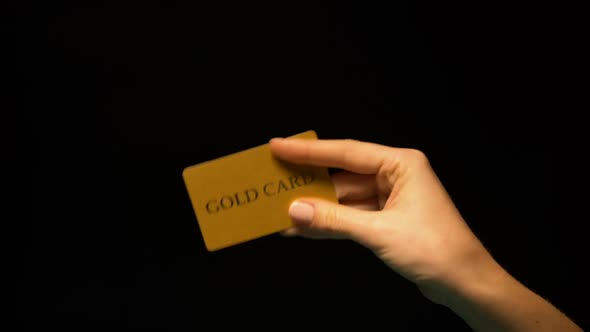 Hand Showing Gold Card on Black Background, Status Vip, Unlimited Finances