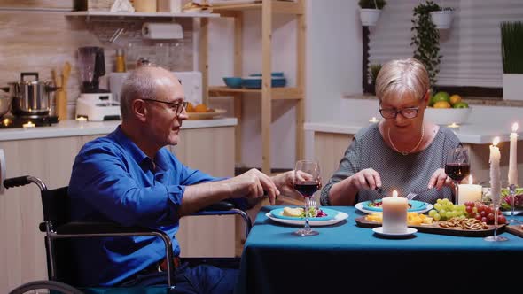 Man in Wheelchair Dining with Wife