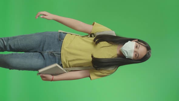 Asian Girl Student Wearing A Mask, Holding Book While Walking To School On Green Screen Chroma Key