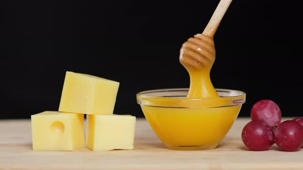 Cheese, Honey and Grapes. Man tasting cheese with honey and grapes