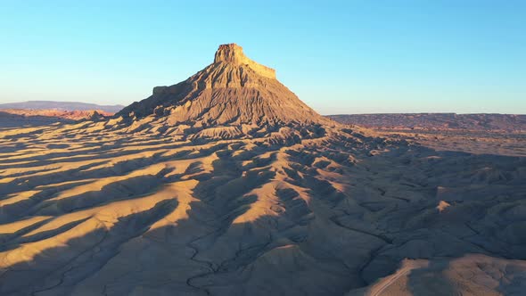 Factory butte and badlands at sunset, Utah. Aerial forward approach