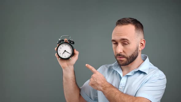 Male Pointing on Alarm Clock Reminding Deadline Limitation