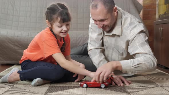 Dad and child playing toy car. 