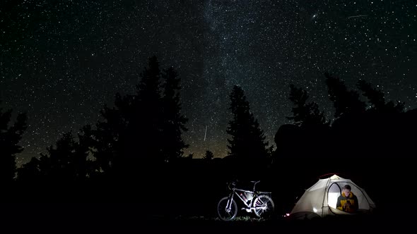 A Man Reads a Book in a Tent