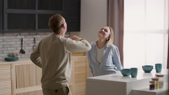 Happy Cheerful Couple Dancing On Kitchen While Cooking Together