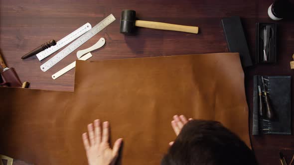 Tailor Spreading Out the Cow Brown Leather and Cleaning It with Brush Before Working