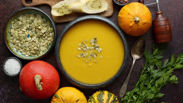 Homemade Vegetarian Pumpkin Cream Soup Served in Ceramic Bowl. Decorated with Seeds