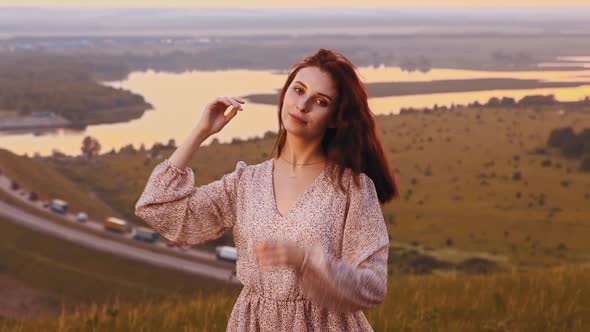 Young Ginger Woman with Pretty Face with Freckles Flaunts on Sunset Field