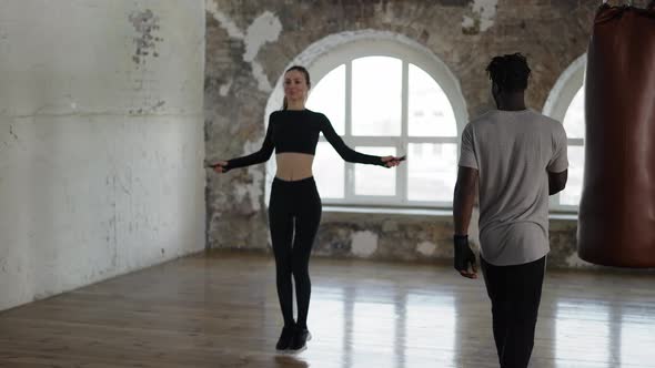 Personal Muscular Trainer Working with Woman Supervising Skipping Rope Exercise