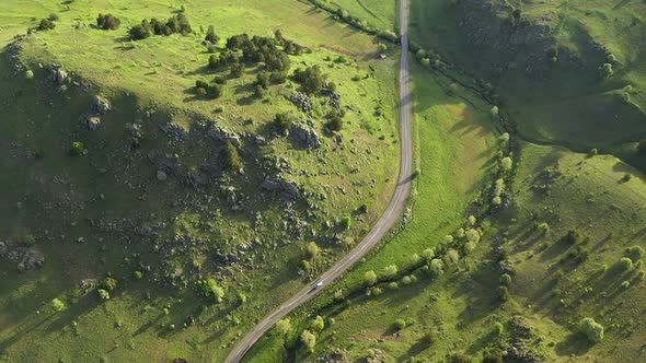 Aerial View Of A Mountain Road Between Meadows And Cliffs