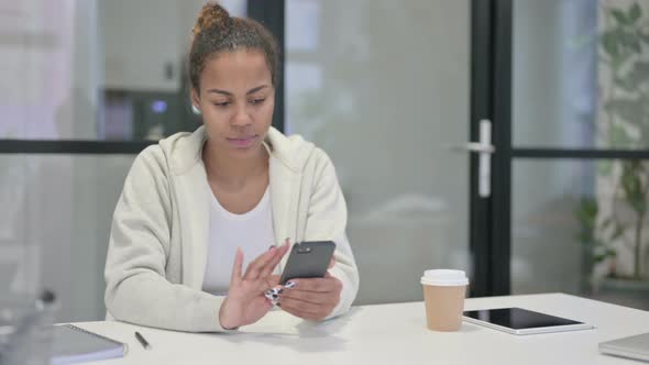 Upset African Woman Reacting to Loss on Smartphone