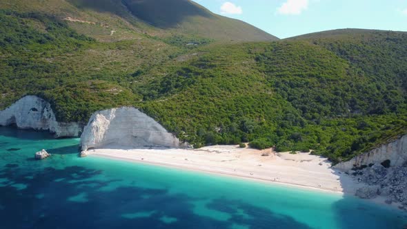 Summer vacation holiday. Fteri beach lagoon with rocky coastline, Kefalonia, Greece. Tourists chill