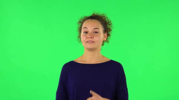 Portrait of Curly Woman Listening Attentively and Nodding His Head Pointing Finger at Viewer. Green