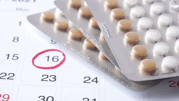 Birth Control Pills  Calendar and Notepad on Table