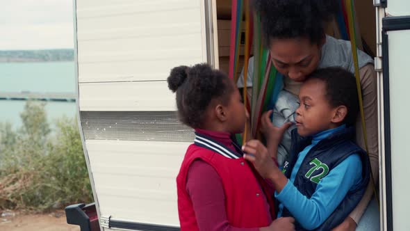 Happy African mom talking with her children in trailer