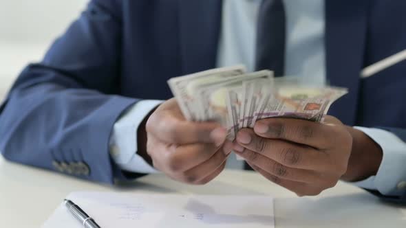 Hands of African Businessman Counting Dollars Close Up