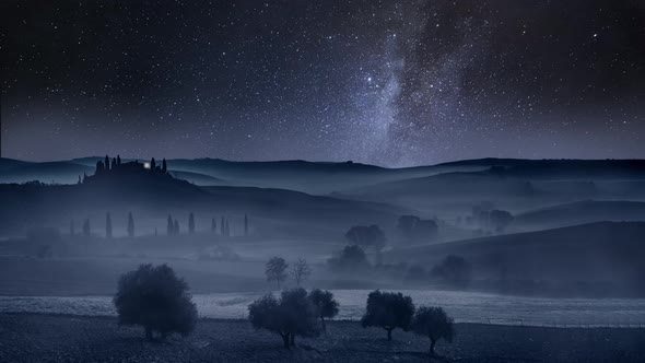 Milky way and falling stars over valley in Tuscany, Italy