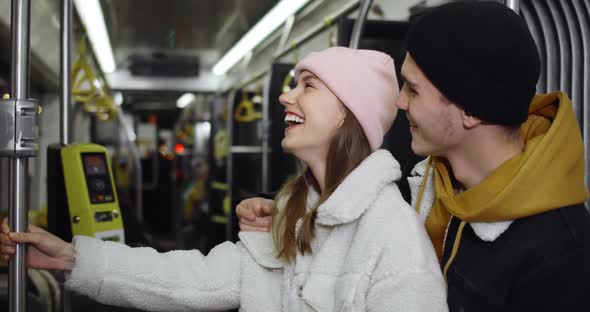 Happy Guy Embracing Attractive Girl While They Going on Public Transport. Millennial Cheerful Couple
