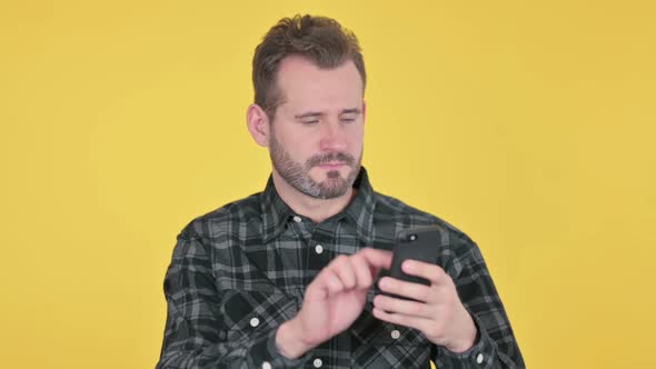 Portrait of Middle Aged Man Celebrating on Smartphone