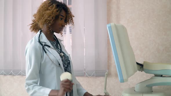 African American Woman Doctor Examines Patient. Ultrasound Devices Monitor Close-up. Possession of