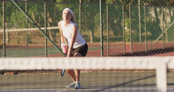 Video of focused caucasian female tennis player holding racket and hitting ball