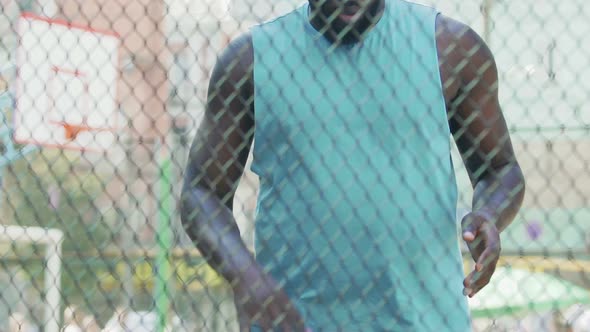 African American Guy Handling Ball Warming up Muscles Before Basketball Training