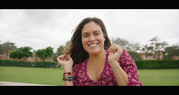 Woman Smiling at Camera While Spinning in Merry Go Round