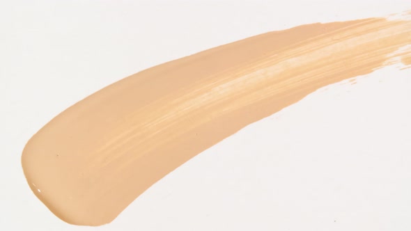 Macro Shot and Slow Motion of a Brush Applicator Smear Concealer Isolated on White Background