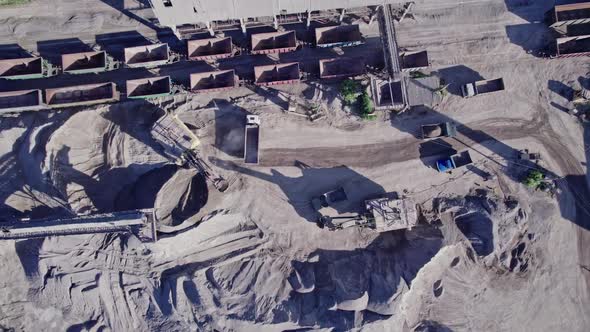 Excavator Loading Crushed Stone Into a Dump Truck in a Crushed Stone Quarry