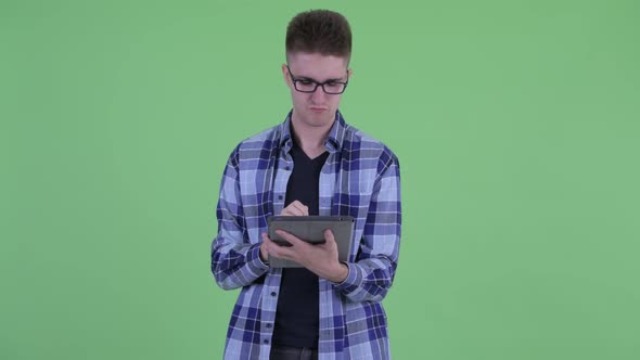 Happy Young Hipster Man Thinking While Using Digital Tablet