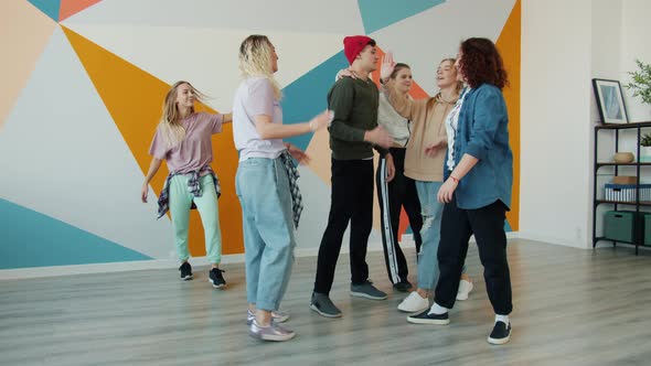 Slow Motion of Young People Dancers Doing High-five Talking and Smiling After Training in Studio