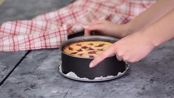 Close Up of the Hands of a Woman Removing the Mold From the Cheesecake