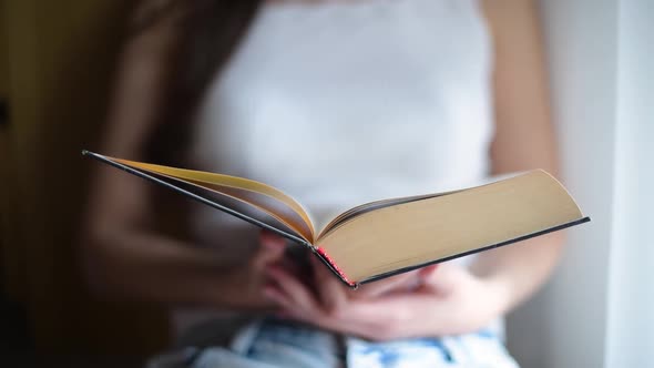 girl closes the book she has read, close-up of the end of the book