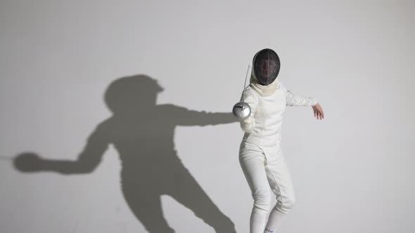 Portrait of a Young Woman Fencer Saluting with Rapier Putting on Helmet and Throwing Attacking Blows