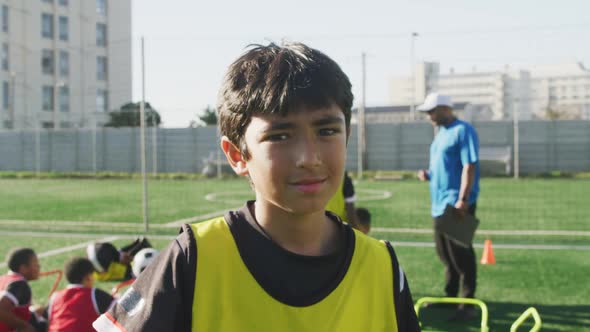 Mixed race soccer kid exercising in a sunny day