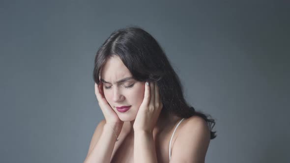 Beautiful Young Woman Closing Ears and Eyes Shaking Head Suffering of Loud Noise