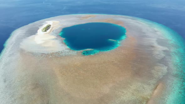 Aerial: Flying over idyllic atoll, scenic travel destination in Indonesia