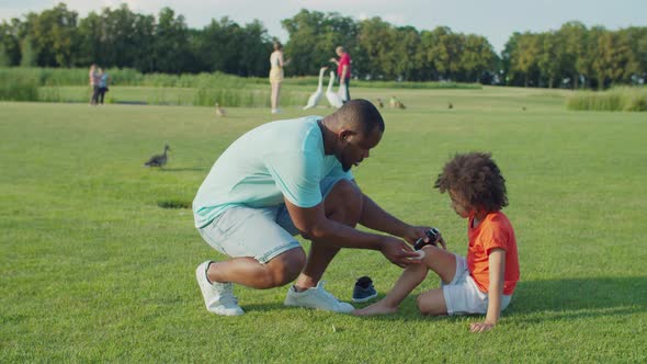 Caring Dad Cleansing with Antiseptic Sons Wound