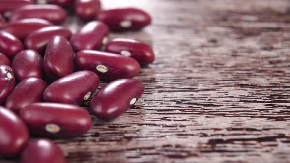 Uncooked red kidney beans on a rustic brown wooden surface. Macro