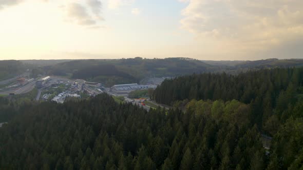 Aerial view descending above woodland to Circuit De Spa-Francochamps racetrack Stavelot Belgium